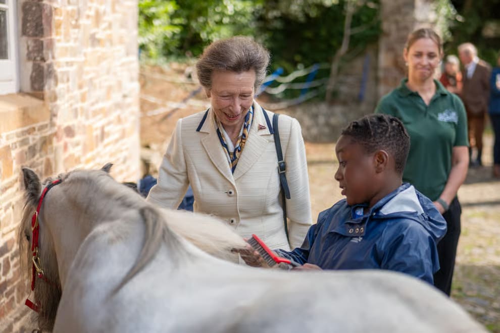 Anne chats to a youngster grooming one of the Nethercott House horses during her visit to mark the 50th anniversary of Farms for City Children.